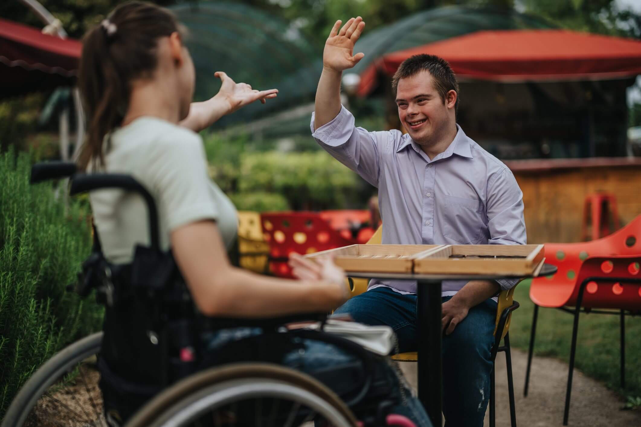 Two men greeting each other, one in a wheelchair.