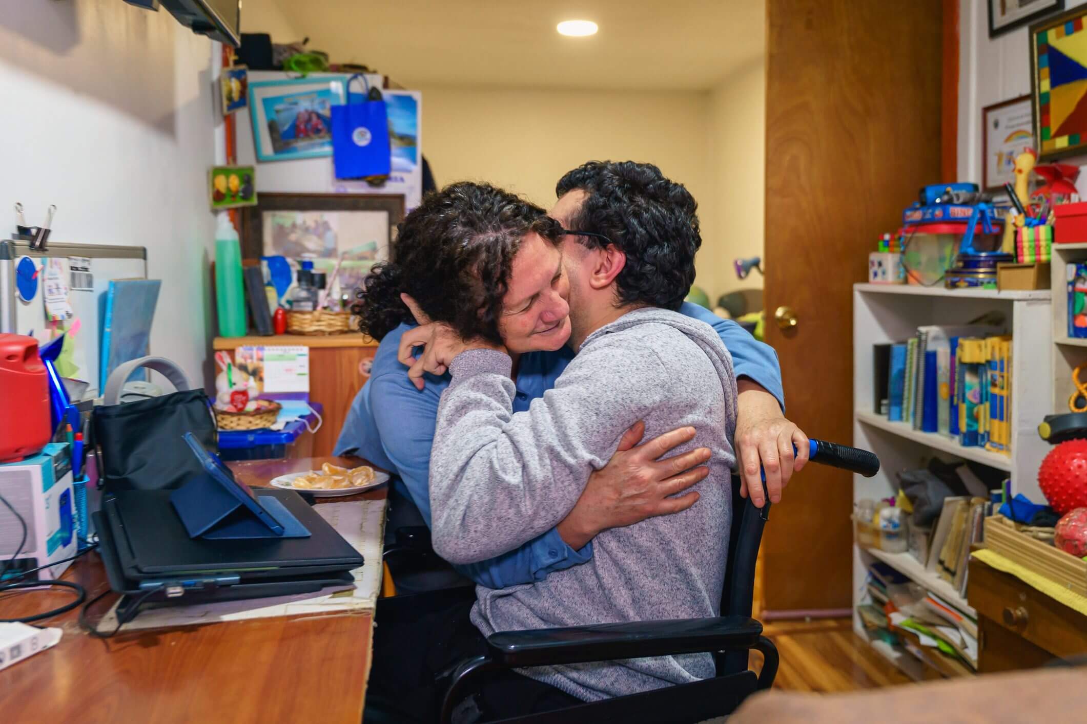 Two women sharing a heartfelt hug in a cozy room.