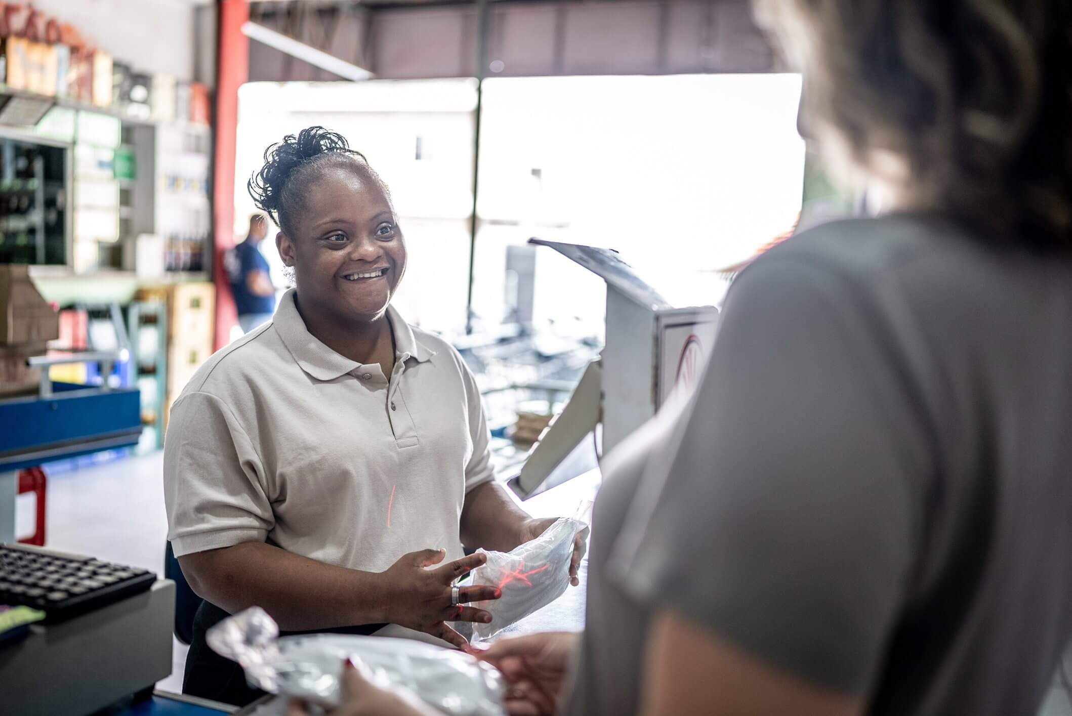 Smiling woman assisting a customer at a service counter.